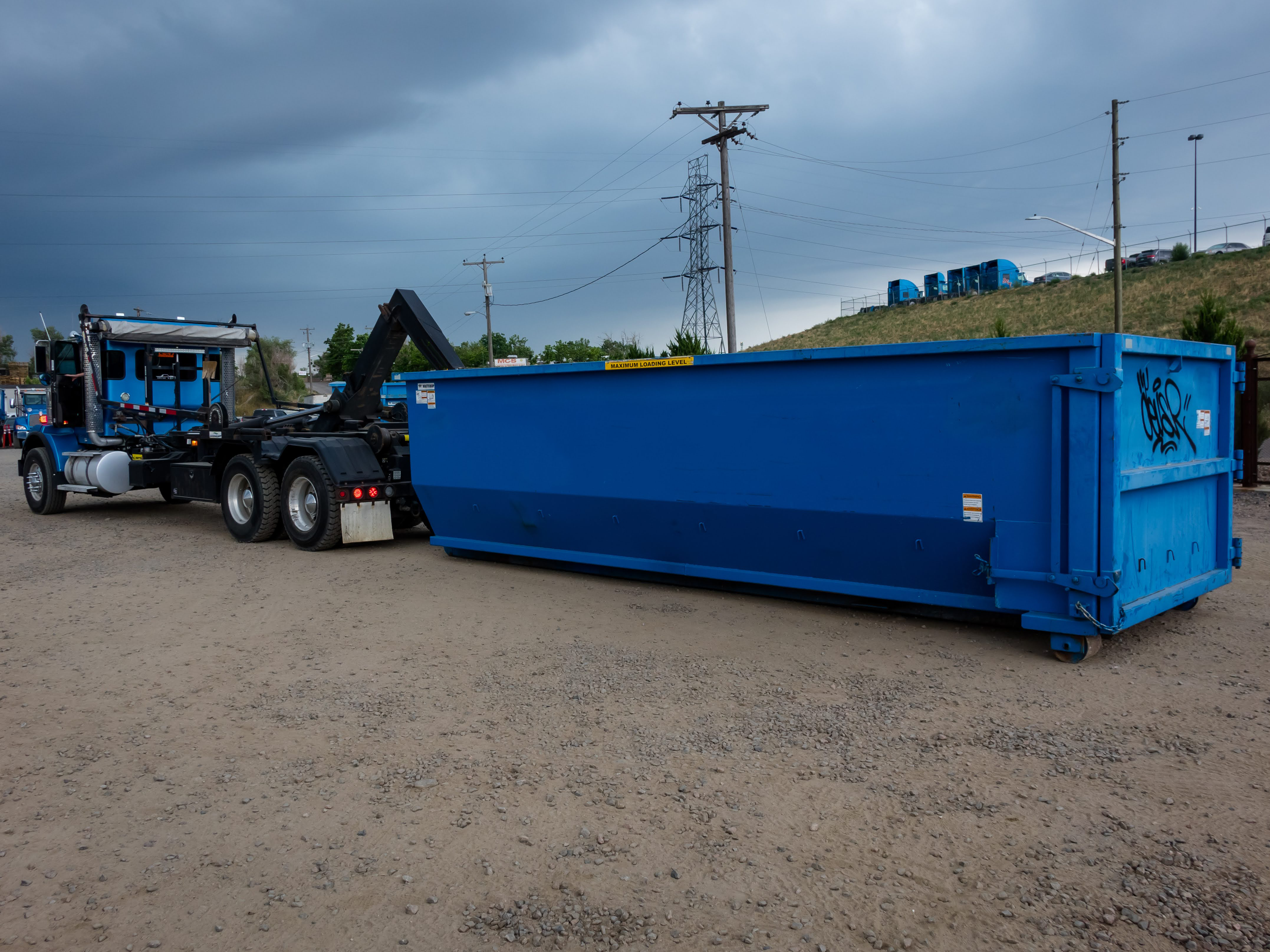 A blue 30 yard roll off dumpster that has been delivered