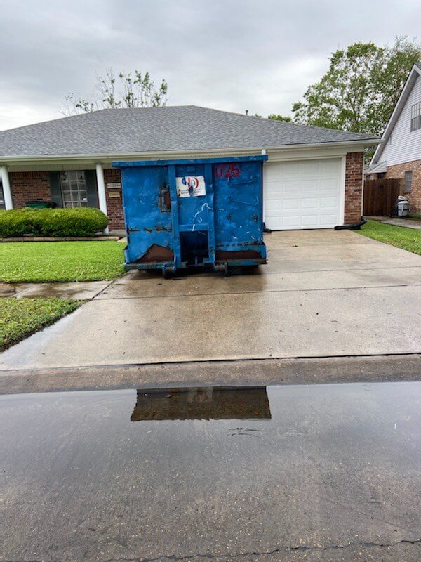 Photo of a blue dumpster rental in Baltimore, MD, parked in a residential space