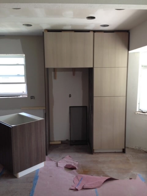 an empty spot under kitchen cabinets where a refrigerator was before it was removed