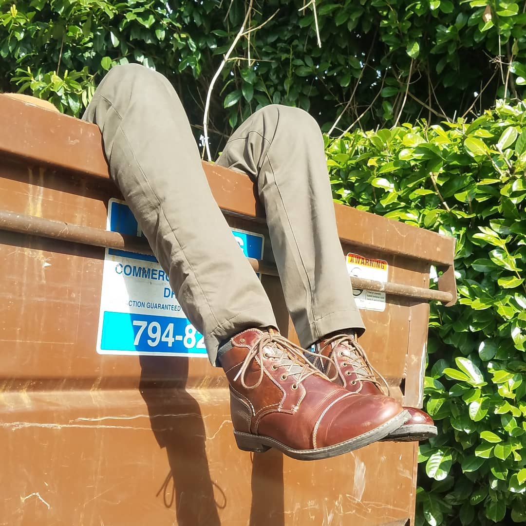A dumpster with feet hanging out.