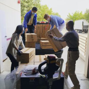 Four people unloading moving boxes