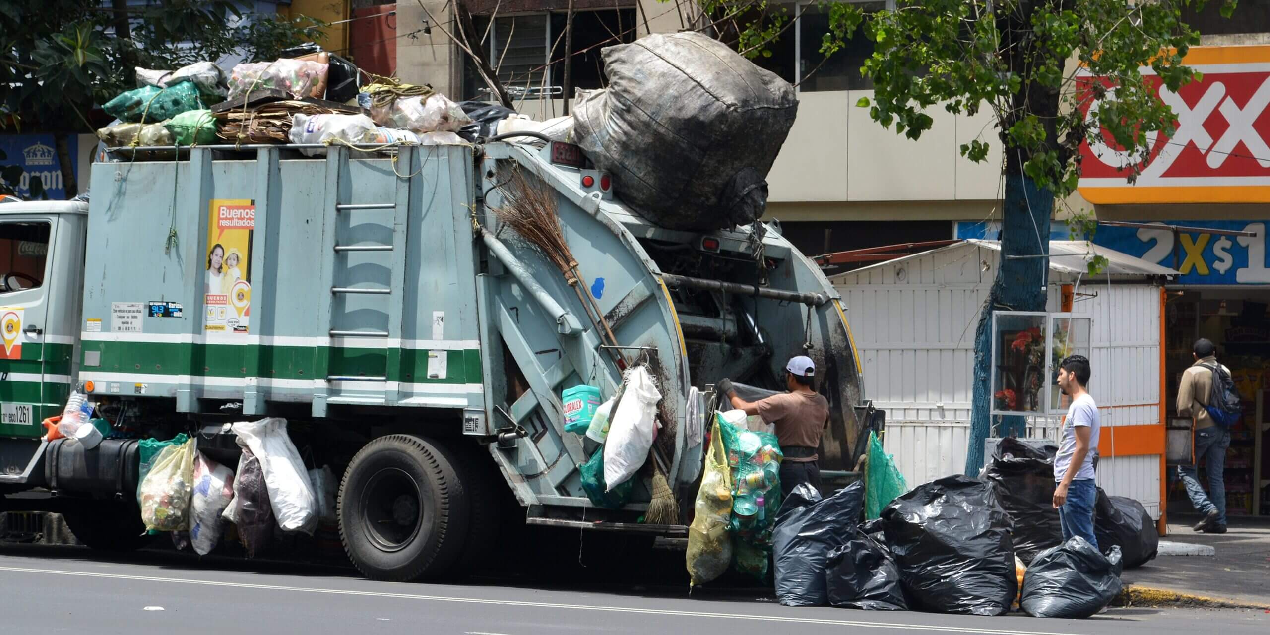Garbage truck drivers dealing with a lot of trash.
